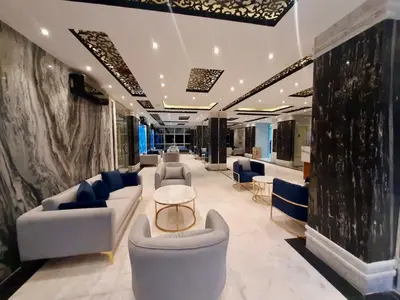 a living room with couches and chairs in a building at Large Studio Beach & Pool Hurghada - Wifi in Hurghada