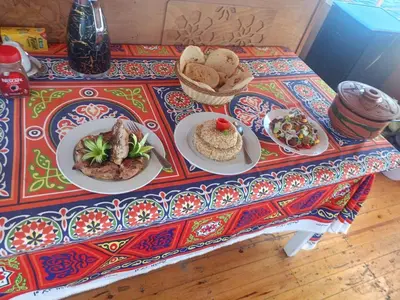 a table with two plates of food on it at King Arthur luxury Dahabyaa in Luxor