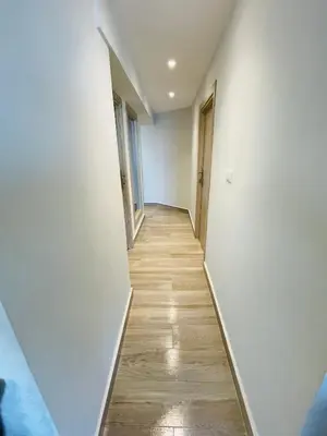 a hallway with white walls and a wooden floor at New Marina Luxury Suite in Hurghada
