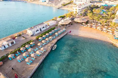 an aerial view of a beach with chairs and umbrellas at Geisum beach hotel in Hurghada
