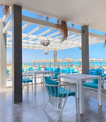 a dining room with blue chairs and tables and the ocean at Fanadir Bay in Hurghada