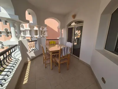 a dining room with a table and chairs on a balcony at K31 Peaceful 2 Bedrooms Nile Resort Flat in Luxor in Luxor