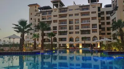 a hotel with a swimming pool in front of a building at Aldau Heights Hurghada in Hurghada