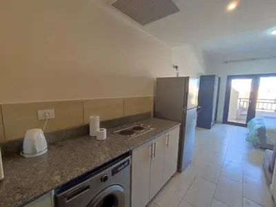 a kitchen with a sink and a washer and a refrigerator at Aldau Heights Hurghada in Hurghada