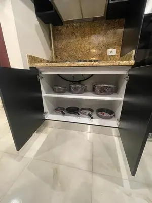 a kitchen with a shelf with dishes on it at Special Apartment For Rent 103 in Hurghada