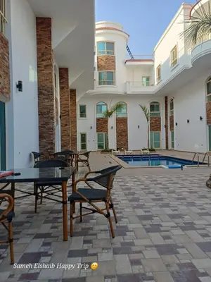 a patio with tables and chairs in front of a building at Suncare America Resort - luxury rooms in Hurghada