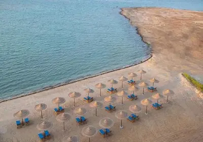 a group of umbrellas and chairs on the beach at Hurghada Sea view with pool in Hurghada