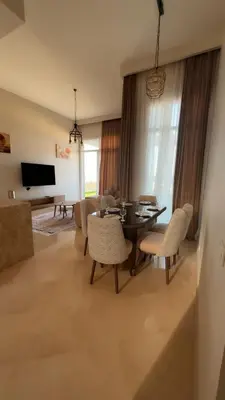 a living room with a dining room table and chairs at Azzurra villa in Hurghada