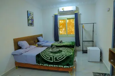 a bedroom with a bed and a table and a window at Aswan City Star in Aswan