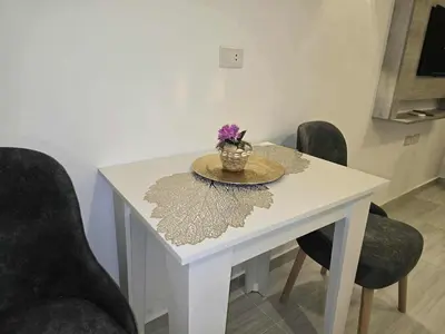 a white table with a vase of flowers on it at El Hambra Compound in Hurghada