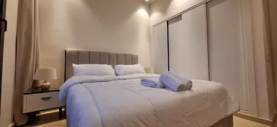 a bedroom with a large bed with white sheets and pillows at El Gouna Luxury 1BR Golf Apartment at Ancient Sands Resort Pool, Beach & Marina Access in Hurghada