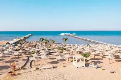 a beach with a lot of umbrellas and the ocean at alkarma nubia apartment 1521 in Hurghada