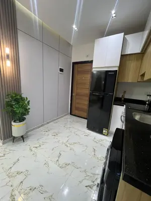 a kitchen with marble floors and a black refrigerator at La Bela Resort in Hurghada