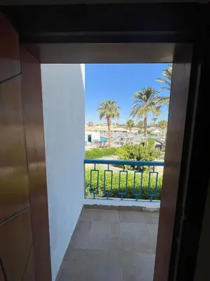 a room with a view of a balcony with palm trees at شاليه بمنتجع ميراج Mirage apartments in Hurghada