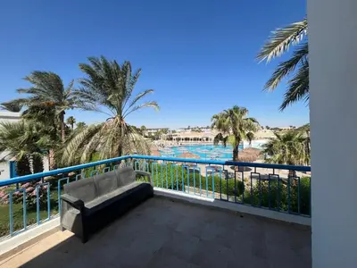 a balcony with a bench and a view of a pool at شاليه بمنتجع ميراج Mirage apartments in Hurghada