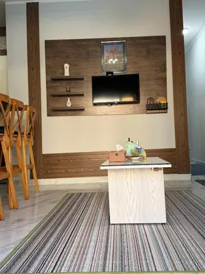 a living room with a table and a tv on the wall at Inter Prime apartment 4 in Hurghada