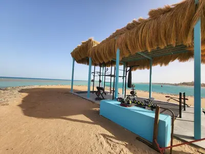 a straw hut on the beach with the ocean at Mangroovy - 2Br Commodious Pool&Gouna views Condo in Hurghada