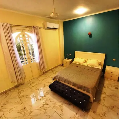 a bedroom with a bed and a green wall at family villa private pool in Luxor