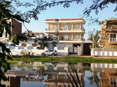 a house with a reflection in a body of water at family villa private pool in Luxor