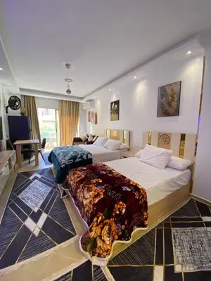 a bedroom with two beds and a living room at فلورينزا الخمسين in Hurghada