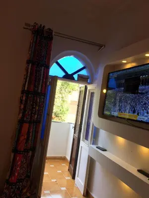 a room with a flat screen tv and a doorway at Gana kato in Aswan