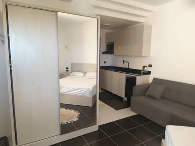 a room with a bed and a kitchen with a mirror at Royal Beach Resort in Hurghada