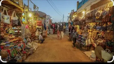 a group of people walking through a market with shops at Arman House in Aswan