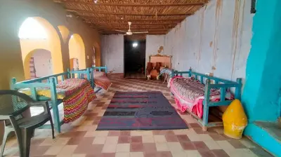 a room with two beds and a rug in it at Arman House in Aswan