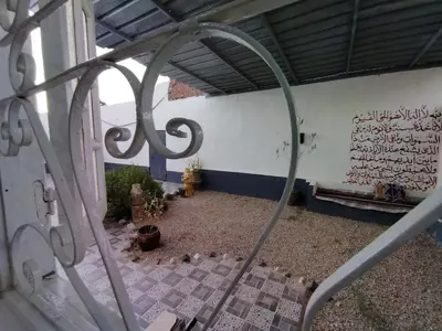a building with a gate with writing on a wall at SAMA HOUSE Cozy Mountain Hideaway in Luxor in ‘Ezbet Abu Ḥabashi