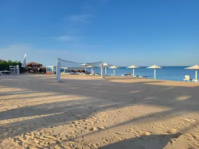 a sandy beach with umbrellas and the ocean at Arena Beach Resort in Hurghada
