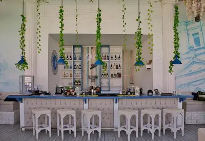 a bar with white stools and a blue counter at Arena Beach Resort in Hurghada