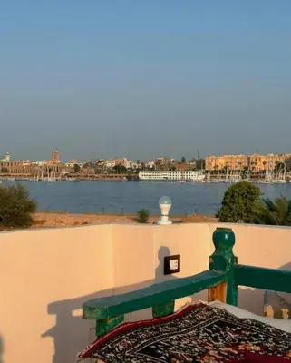 a green bench sitting on a wall next to the water at Morsy Palace in Luxor
