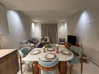 a living room with a table and chairs and a couch at Stylish 1BR Retreat – Ancient Sands El Gouna in Hurghada