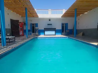 a large swimming pool with a ping pong table at Ashria gest house in Jazīrat Salūjah