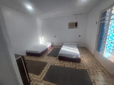 two beds in a room with mats on the floor at Ashria gest house in Jazīrat Salūjah