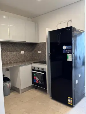a black refrigerator in a kitchen next to a stove at ELGOUNA Maraya duplex pool view in Hurghada