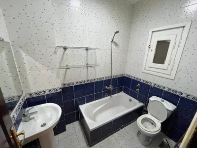 a bathroom with a tub and a toilet and a sink at Cozy Apartment, on Sheraton Road Near Metro Market in Hurghada