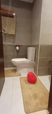 a bathroom with a toilet and a red stool at Luxury Studio Pool & Free Private Beach, Close to Airport in Hurghada