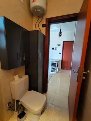 a bathroom with a white toilet and a door at Paradise Vibe Apartment in Hurghada