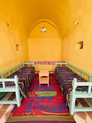 a room with three beds and a red carpet at ايـو كـاتو in Jazīrat ‘Awwāḑ