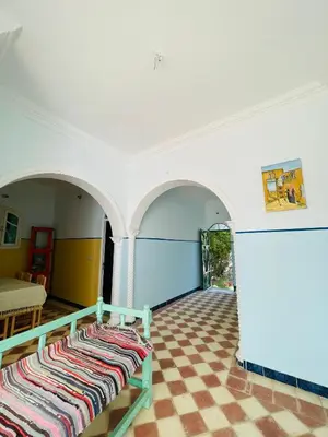 a room with two beds sitting on a checkered floor at ايـو كـاتو in Jazīrat ‘Awwāḑ