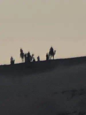 a group of people standing on a hill with a camel at Esmerada in Aswan