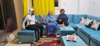 a group of three people sitting on a blue couch at Esmerada in Aswan