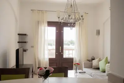 a living room with a couch and a table at Nayah Stays, Cozy lagoons terrace one ensuite Apt in Hurghada