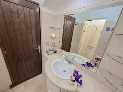 a bathroom with a sink and a toilet and a mirror at Nayah Stays, Cozy lagoons terrace one ensuite Apt in Hurghada
