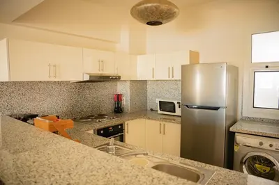a kitchen with a stainless steel refrigerator and a sink at Nayah Stays, Joubal Lagoons Terrace in Hurghada