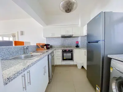 a kitchen with white cabinets and a stainless steel refrigerator at Nayah Stays, Joubal Lagoons Terrace in Hurghada