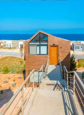 a house on the beach with a orange door at Luxury Stays in Wadi Jebal Soma Bay in Hurghada