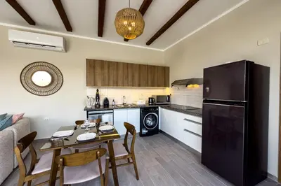 a kitchen with a table and a black refrigerator at Elegance Serene 3 BDR Townhouse w Private Pool Bali Gouna in Hurghada