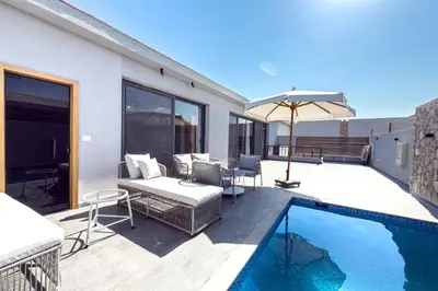 a patio with a swimming pool and an umbrella at Elegance Serene 3 BDR Townhouse w Private Pool Bali Gouna in Hurghada
